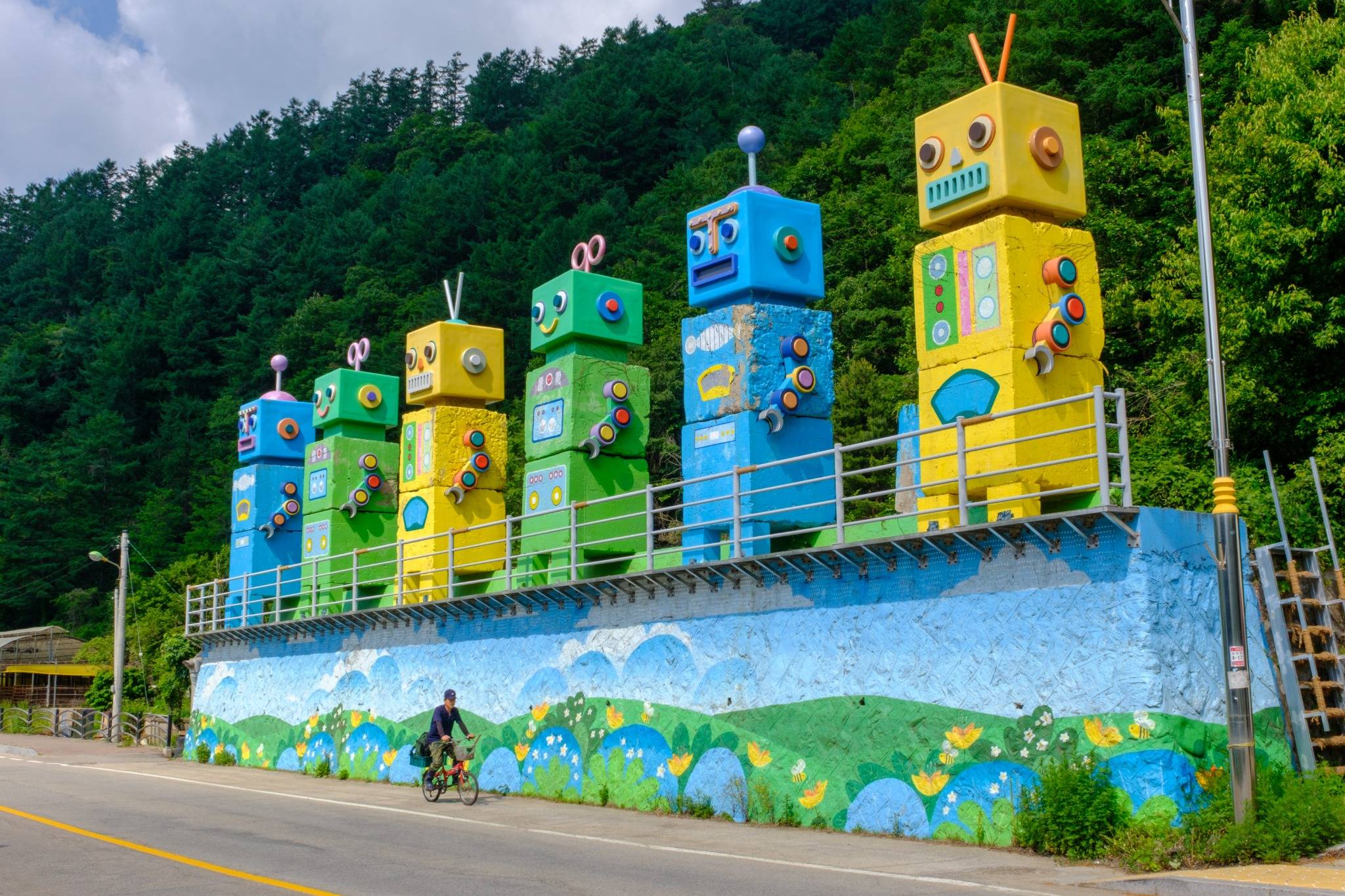 A cyclist passes by a decorated anti-tank obstacle in a village near Hwacheon.
