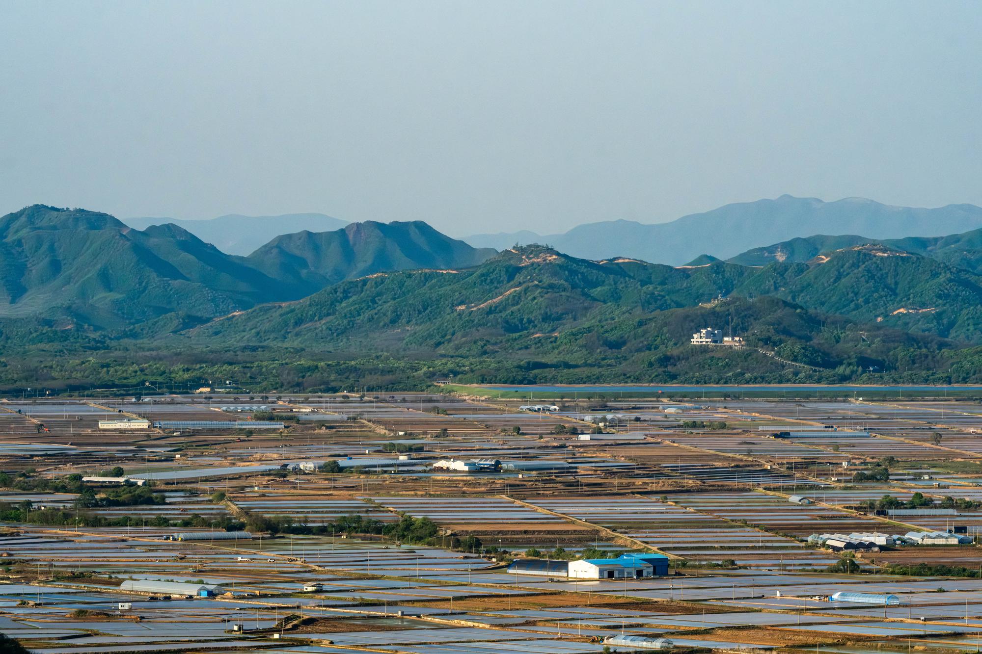 cheorwon-basin-aerial-view-2026 Panorama of the Cheorwon Basin and the DMZ, with the North Korean mountains on the background and South Korean fields on the foreground.