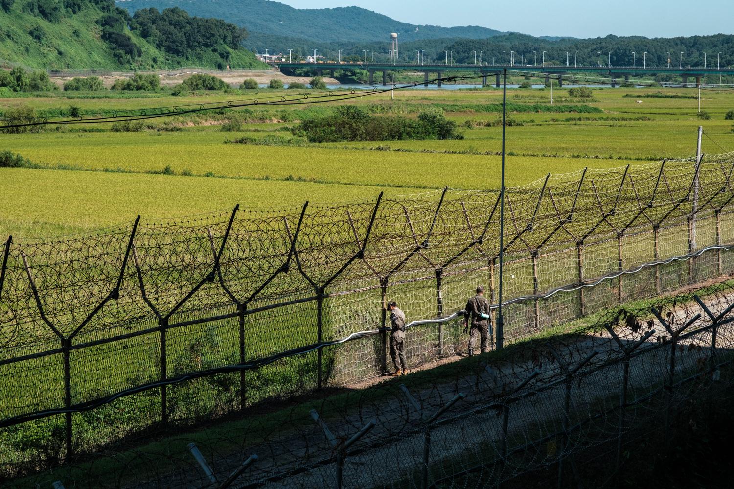 civilian-control-line-unification-bridge-paju South Korean soldiers inspect the Civilian Control Line (CCL) fence in Imjingak, Paju City, with the Unification Bridge over the Imjin River in the background (September 2026).