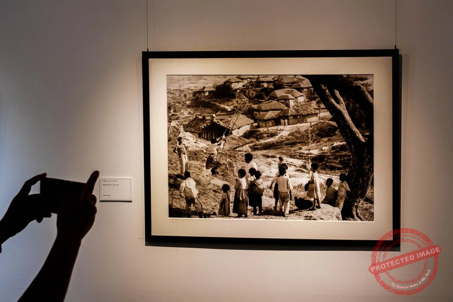 dmz-camp-greaves-17 A tourist takes a photo of an image taken in North Korea by an unknown Czechoslovakian military photographer in the Neutral Nations Supervisory Commission (NNSC) Museum at Camp Greaves (September 2025).