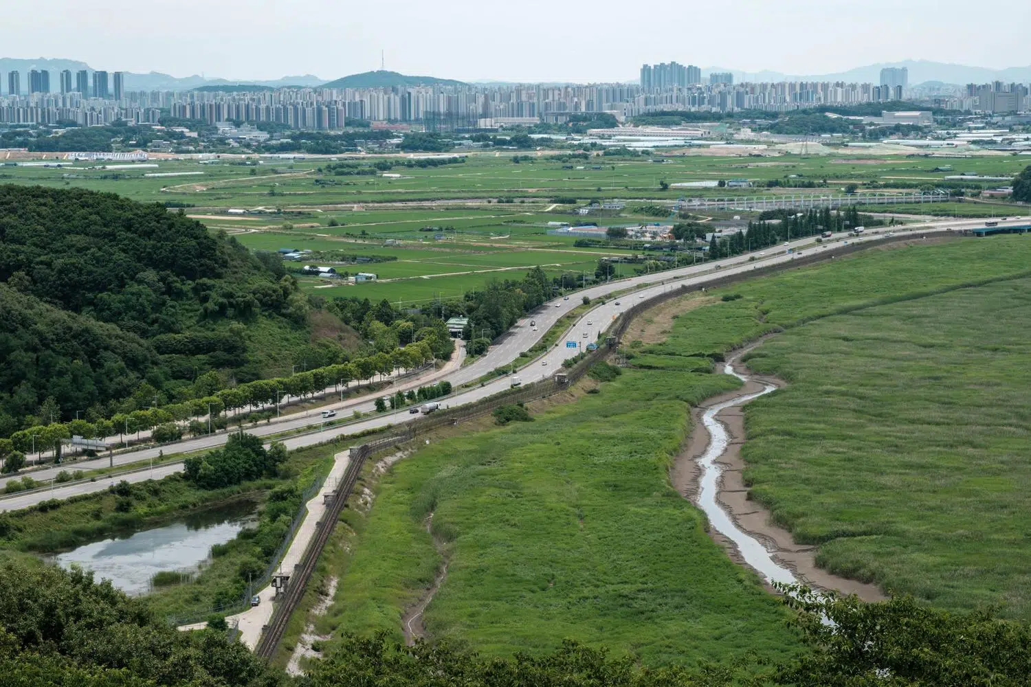 jayu-ro-paju-fence-2026-6 Jayu-ro as it passes through Paju, with the fences along the banks of the River Han designed to prevent infiltration from North Korea (June 2026).