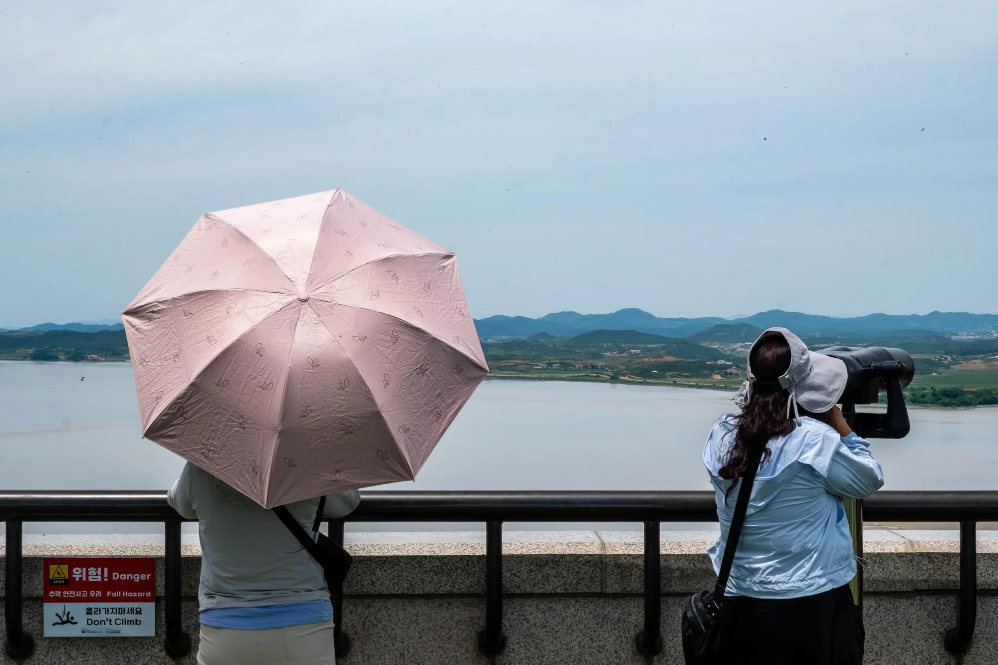 odusan-observatory-north-korea-watchers-umbrella-2026 People watch North Korea through telescopes at Odusan Observatory in Paju (June 2026).