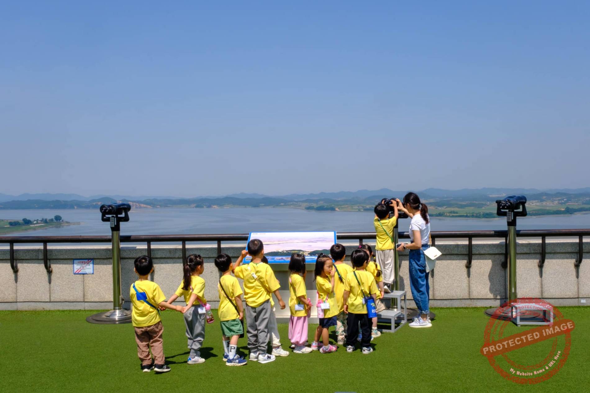 Kindergarten children wait in line to watch North Korea through a telescope at Odusan Observatory's rooftop (June 2025).